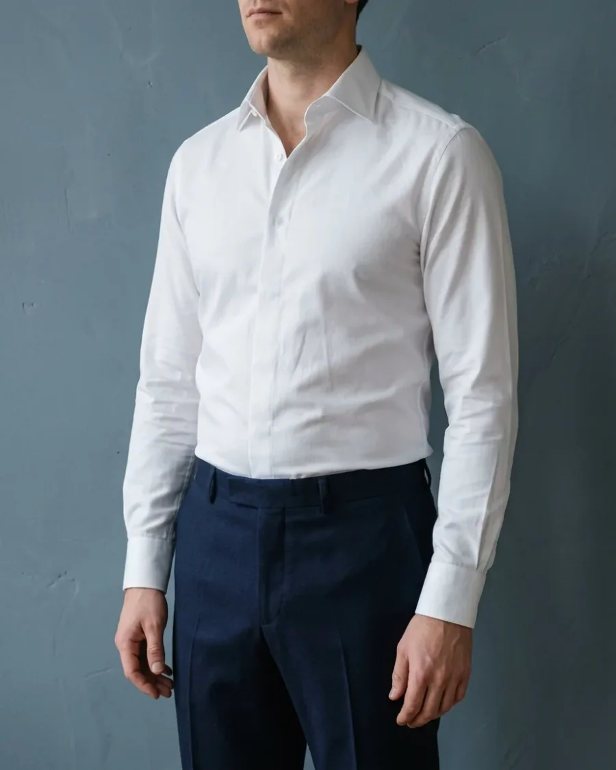 A man wearing a close-fitting white dress shirt